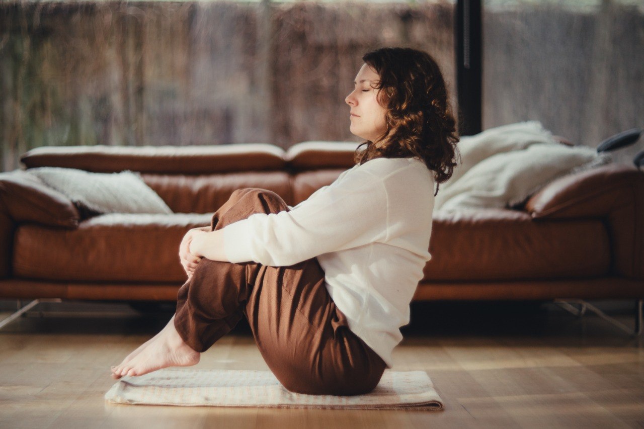 Erin in peaceful meditation practice in natural home setting