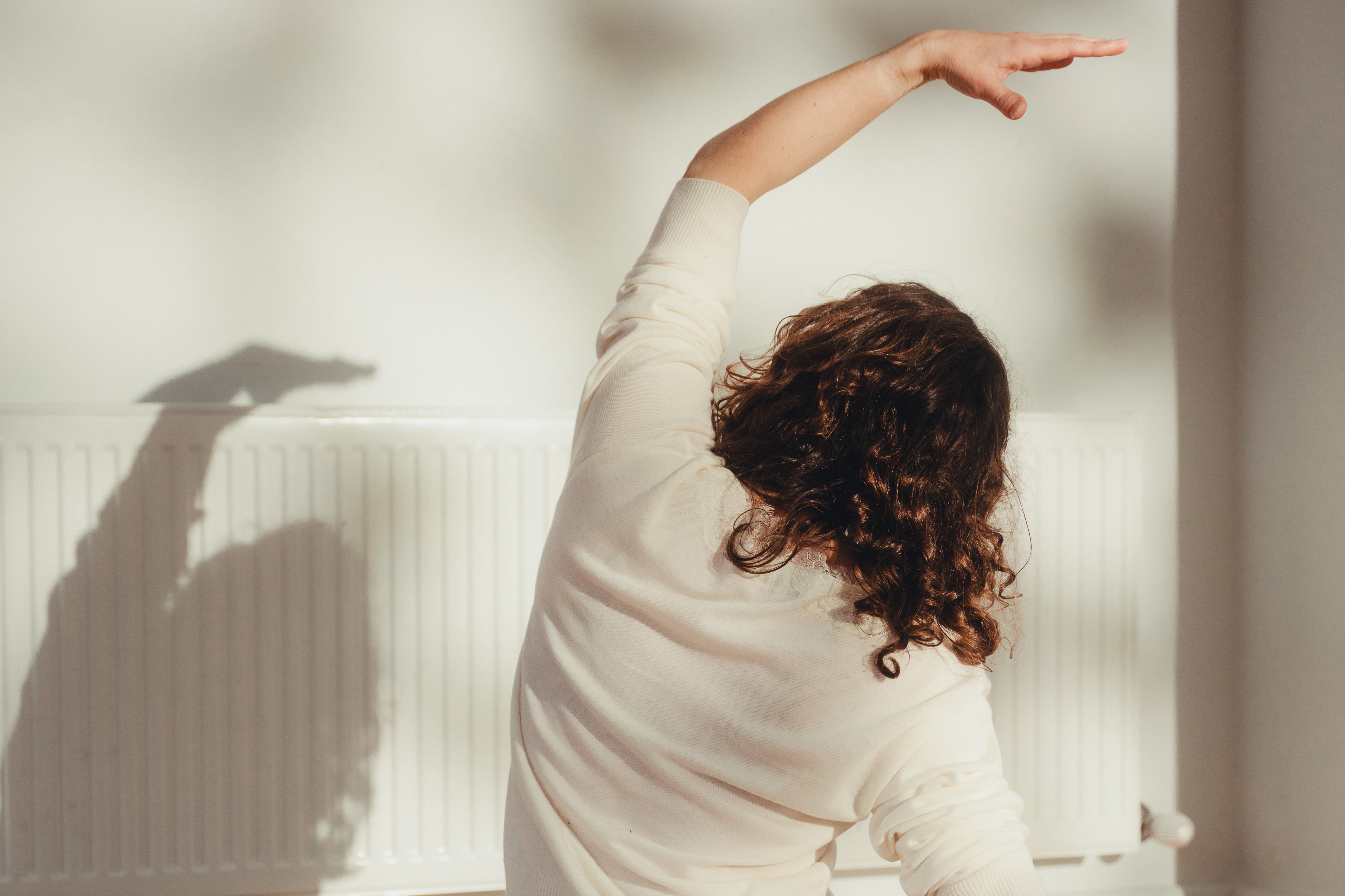Graceful side stretch in soft natural light showing accessible gentle movement