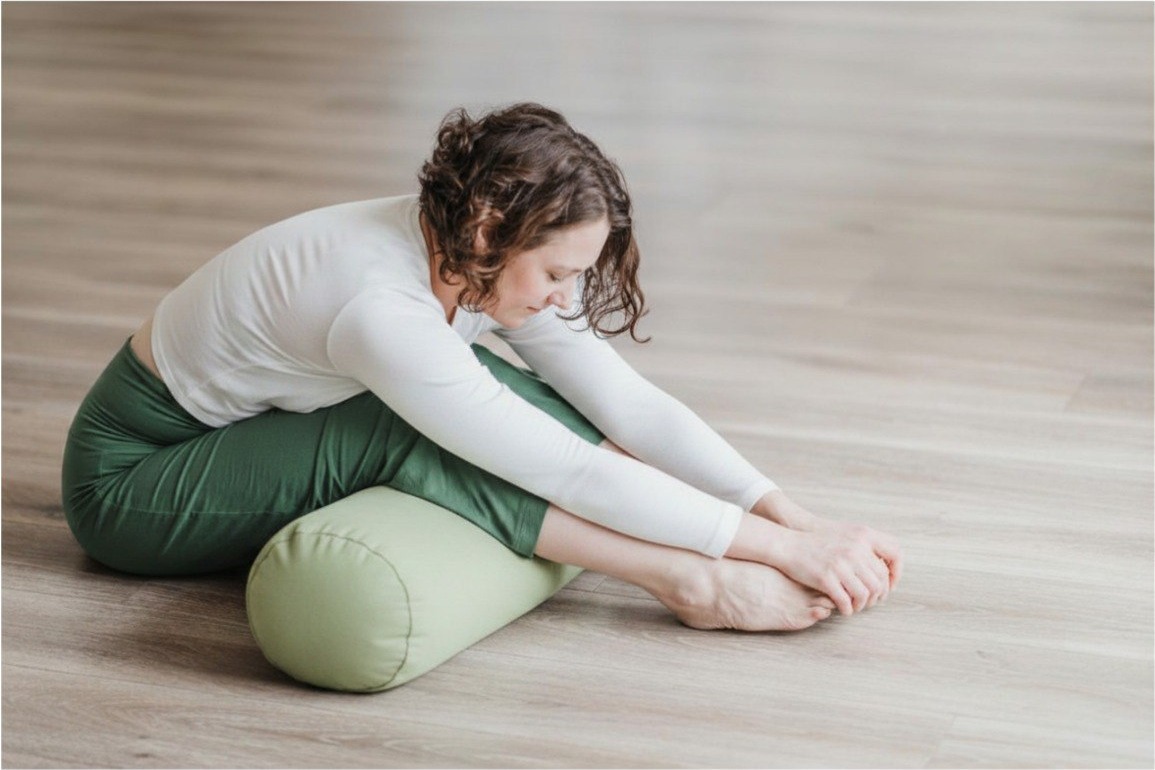 Gentle supported forward fold on a bolster during a Beautiful Yoga class