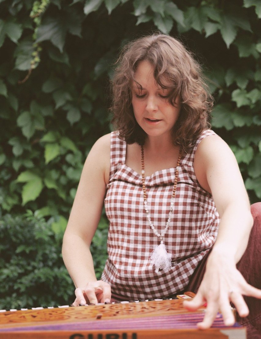 Erin playing harmonium in natural setting - the heart of sound circle practice